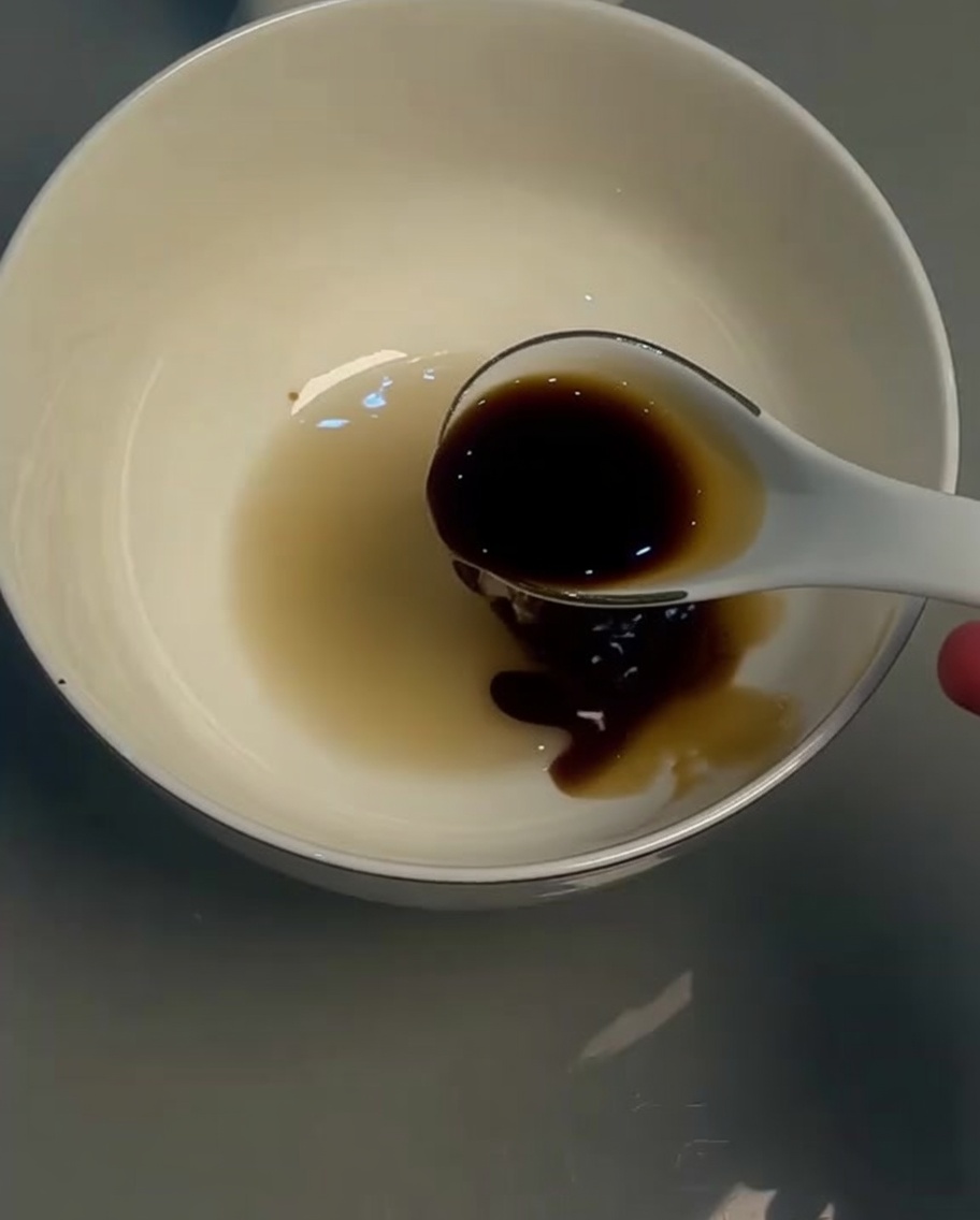 ボウルに入った薄口醤油をスプーンで混ぜる様子。
