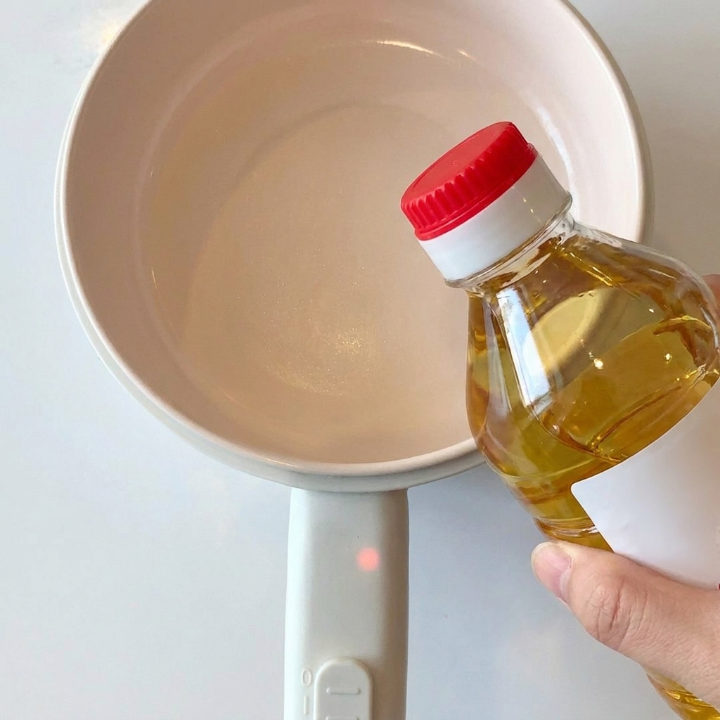 小鍋の中でサラダ油とにんにくを熱している様子。