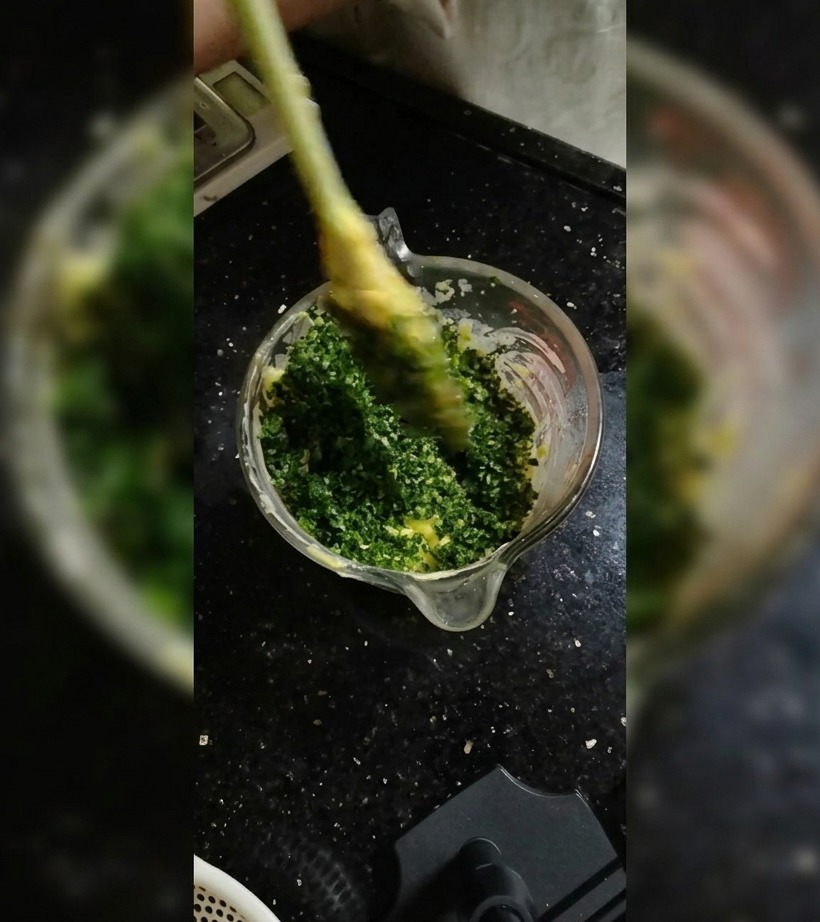 ガラスボウルの中で、シリコンスパチュラを使って柔らかいバターにハーブを練り込んでいる様子。