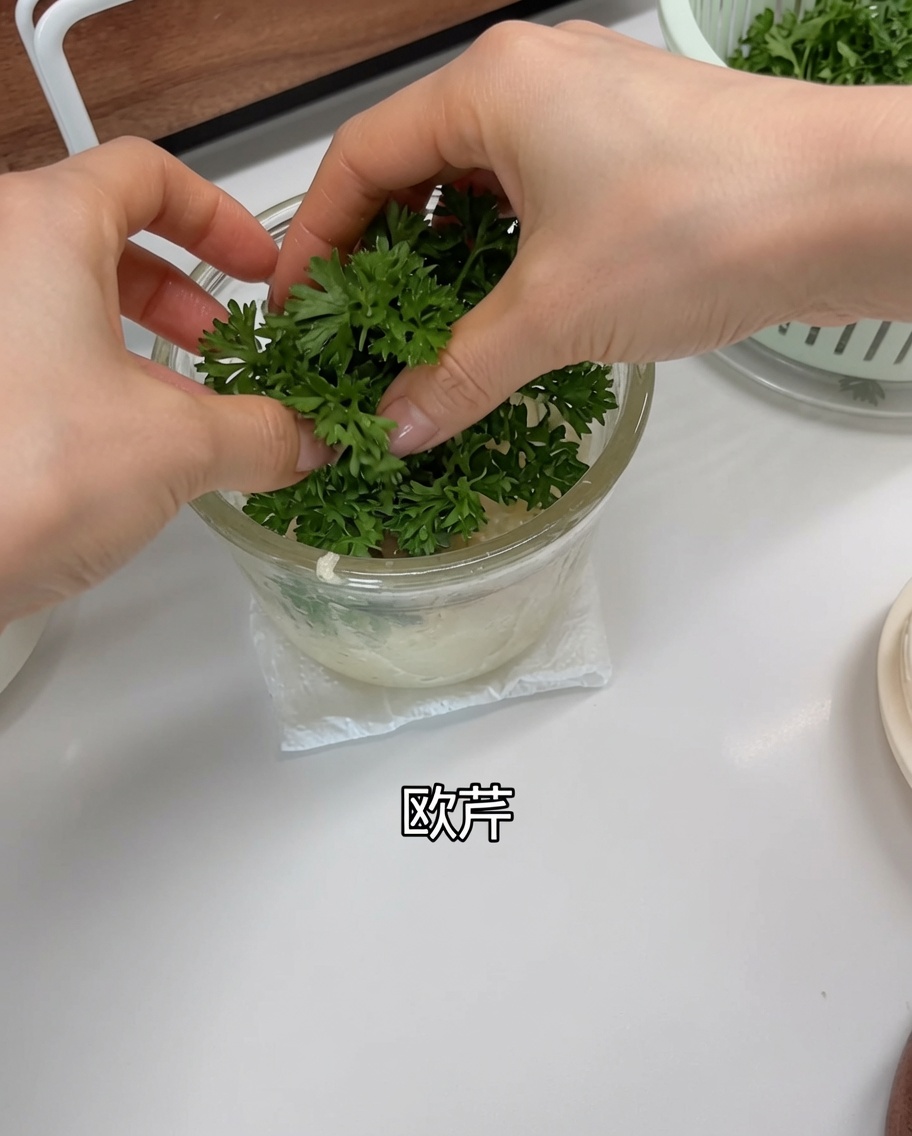 フードプロセッサーのにんにくとエシャロットの上に、洗ったフレッシュパセリを乗せている様子。