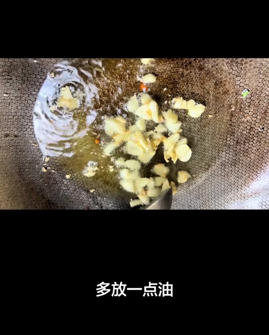 フライパンで熱したオイルの中で香ばしく炒められているニンニクの薄切り。