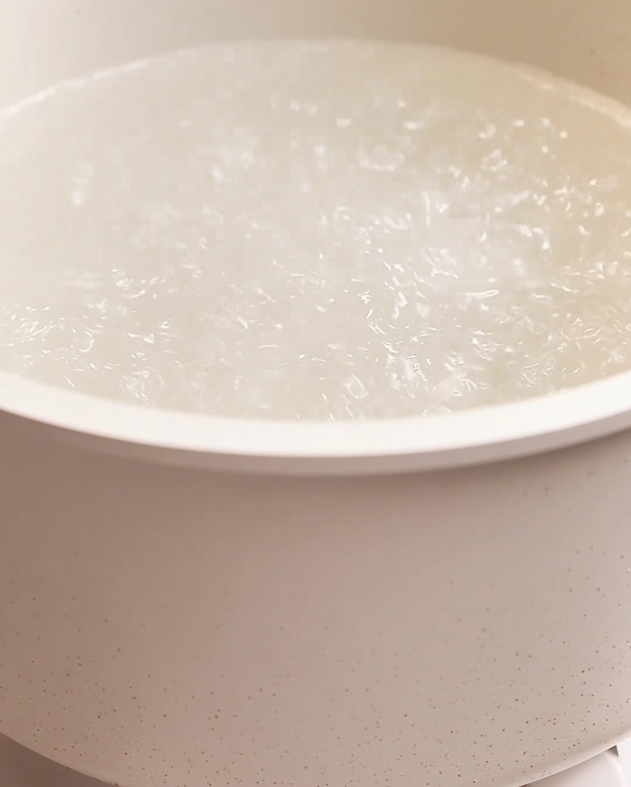大きめの鍋で沸騰したお湯の中で茹でられているスパゲッティ。