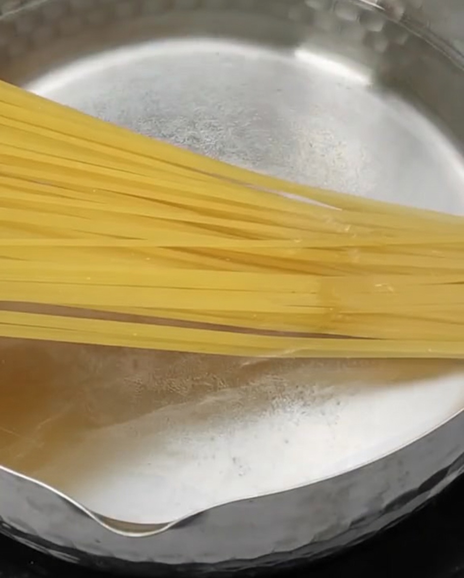 沸騰したお湯に投入されるパスタの麺。