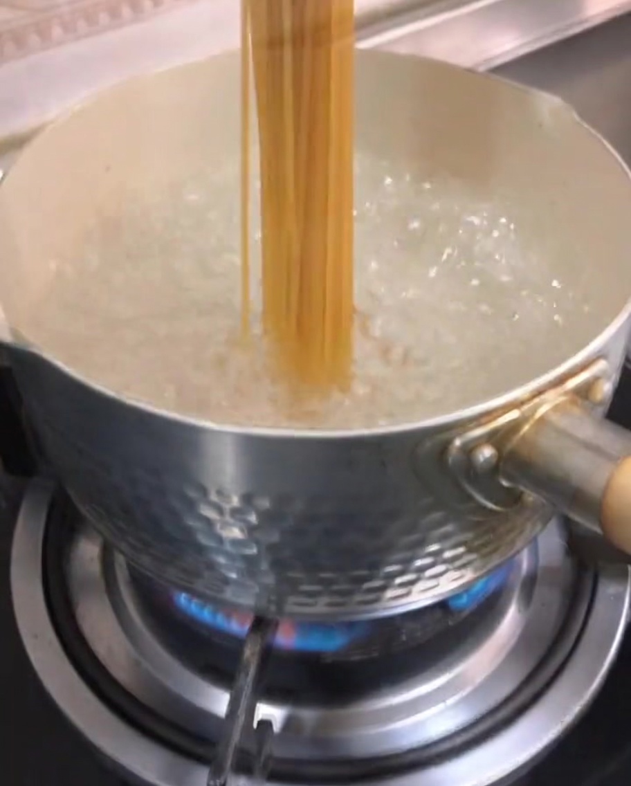 沸騰したお湯に入れられたスパゲッティ。
