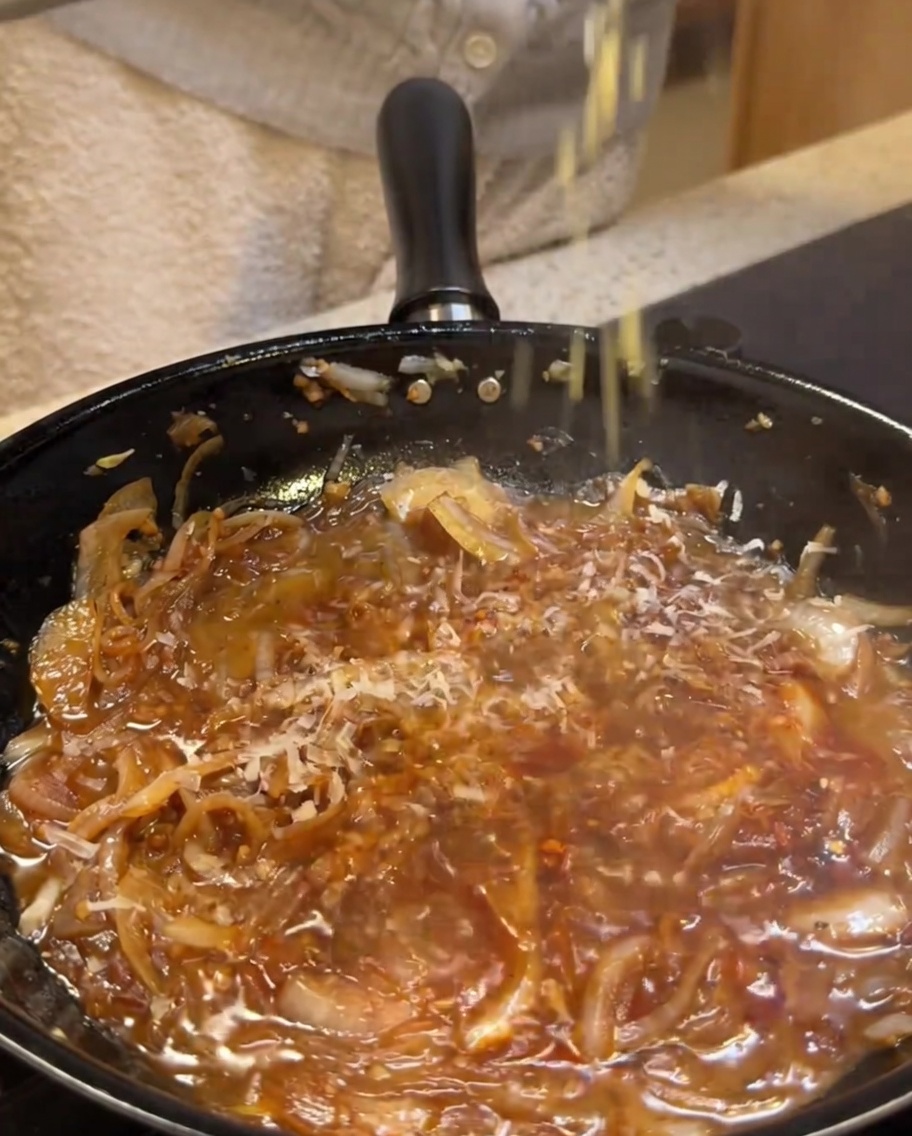 ソースにパルメザンチーズをすりおろしている様子。