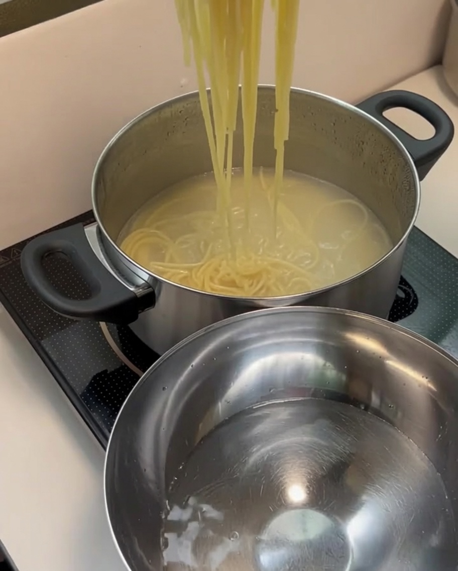 茹で上がったパスタを冷水のボウルに移す様子