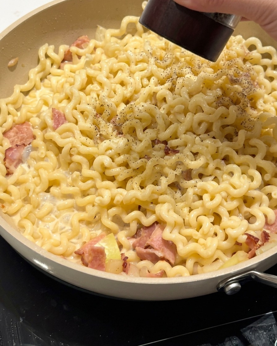 トングでソースと麺を絡める様子