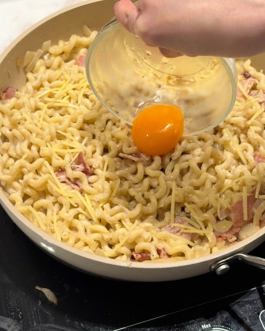 パスタの中心に卵黄を乗せる様子