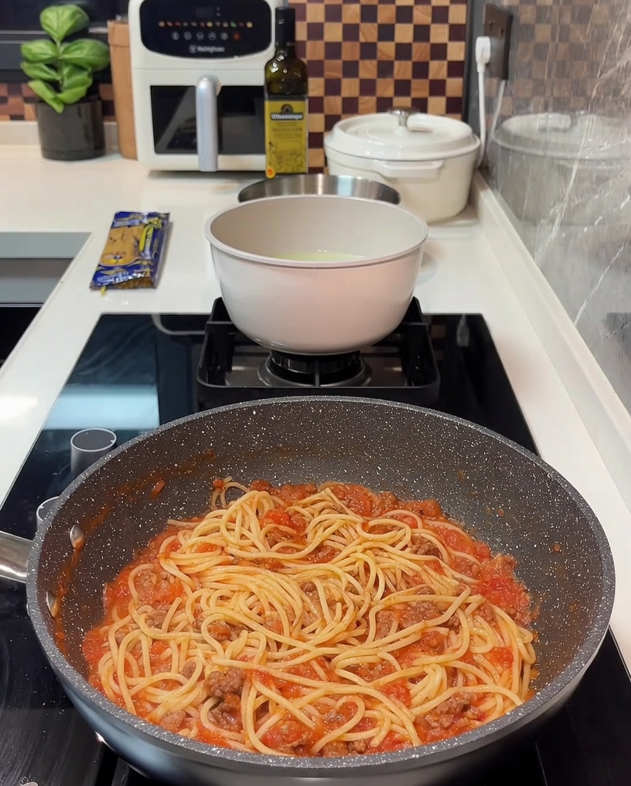 スパゲッティの上にスライスチーズをのせて溶かしている様子。