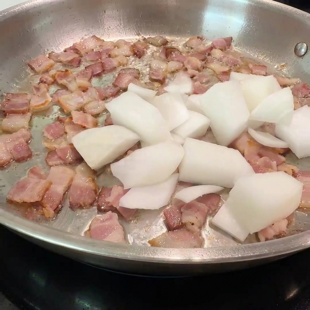 カリカリのベーコンに玉ねぎとキノコを加えて炒めている様子。