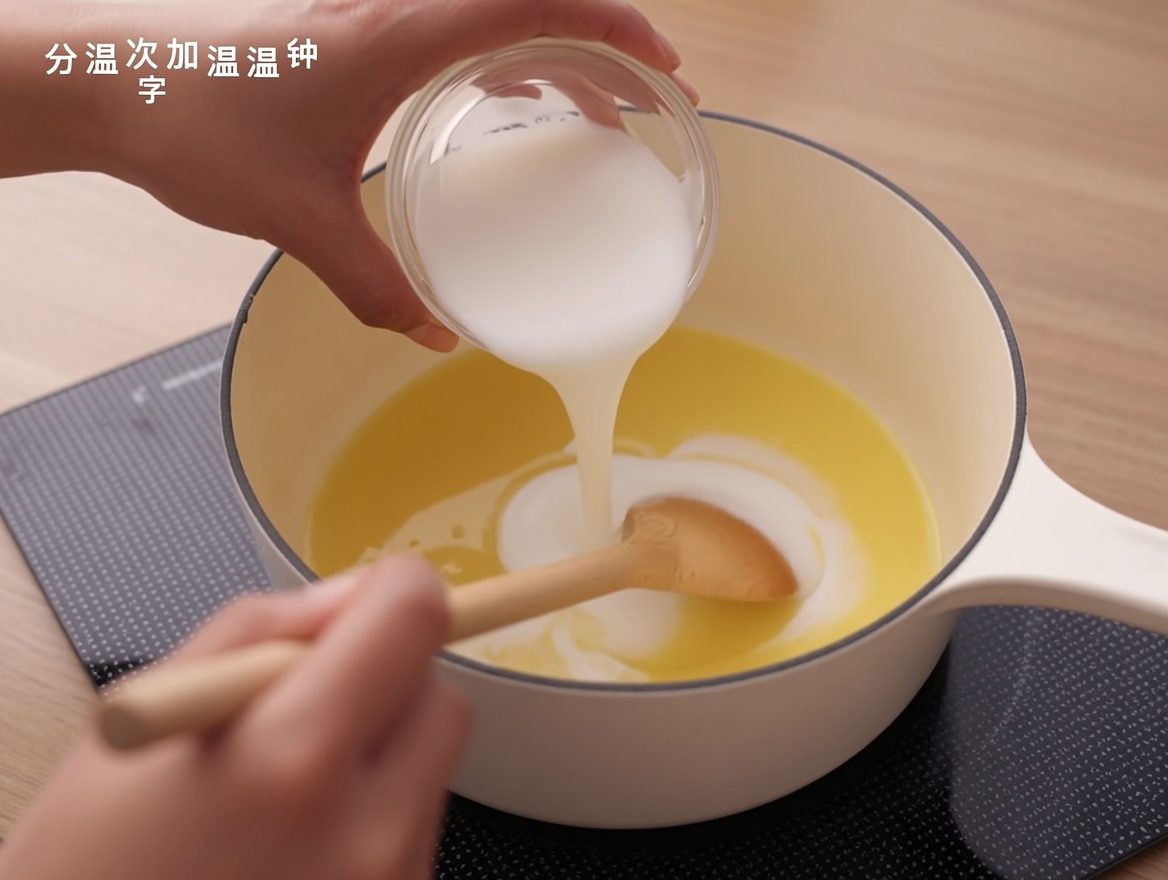 鍋のルーに牛乳を注ぎながら、木べらで混ぜている様子。