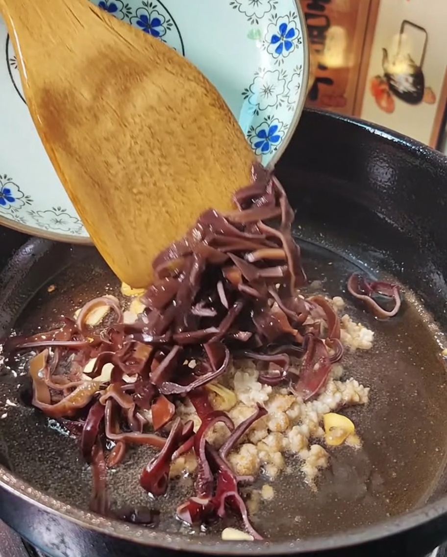 フライパンで豚ひき肉ときくらげを炒めている様子。