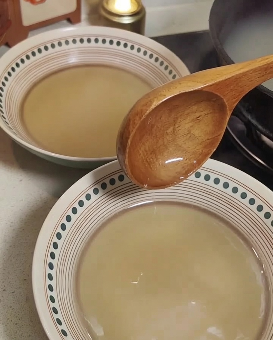 熱い豚骨スープが入った器に麺を入れている様子。
