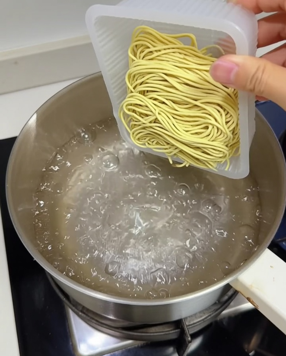 沸騰した鍋に中華麺を入れている様子