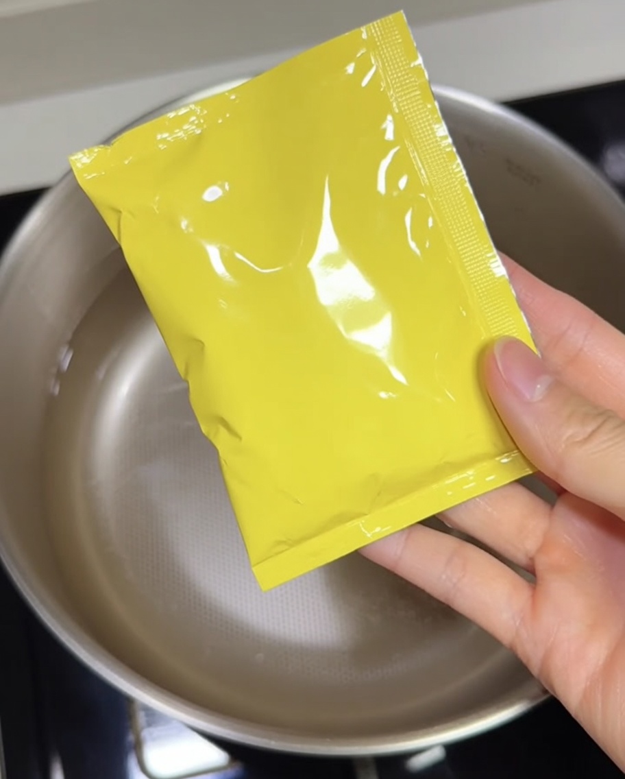 どんぶりに豚骨スープの素を絞り出している様子
