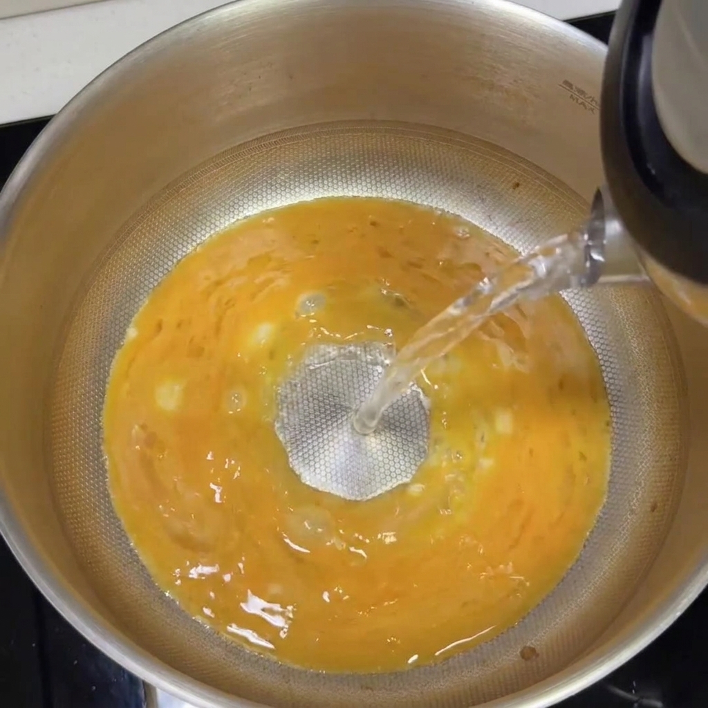 熱湯を加えて豚骨スープを混ぜている様子