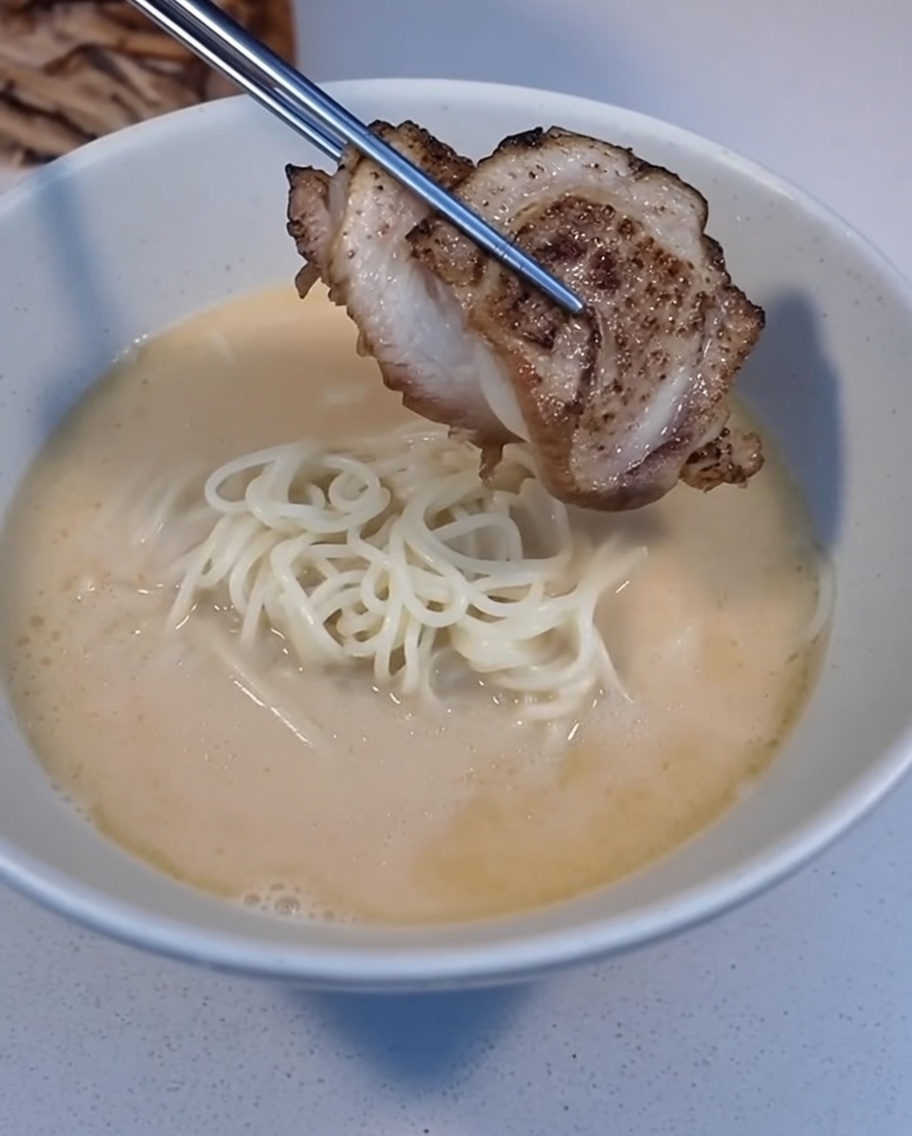ピンセットで炙ったチャーシューを盛り付けている様子