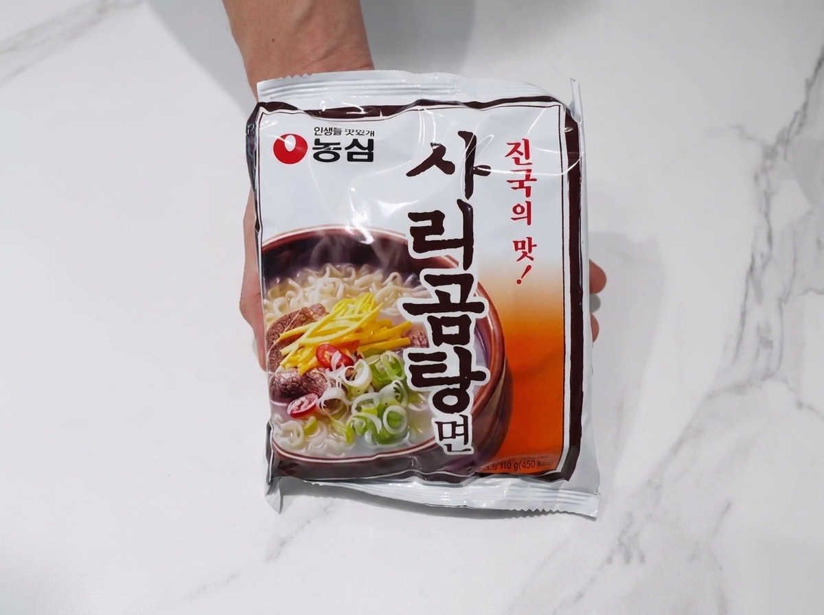 煮立ったスープにラーメンの麺を入れている様子。