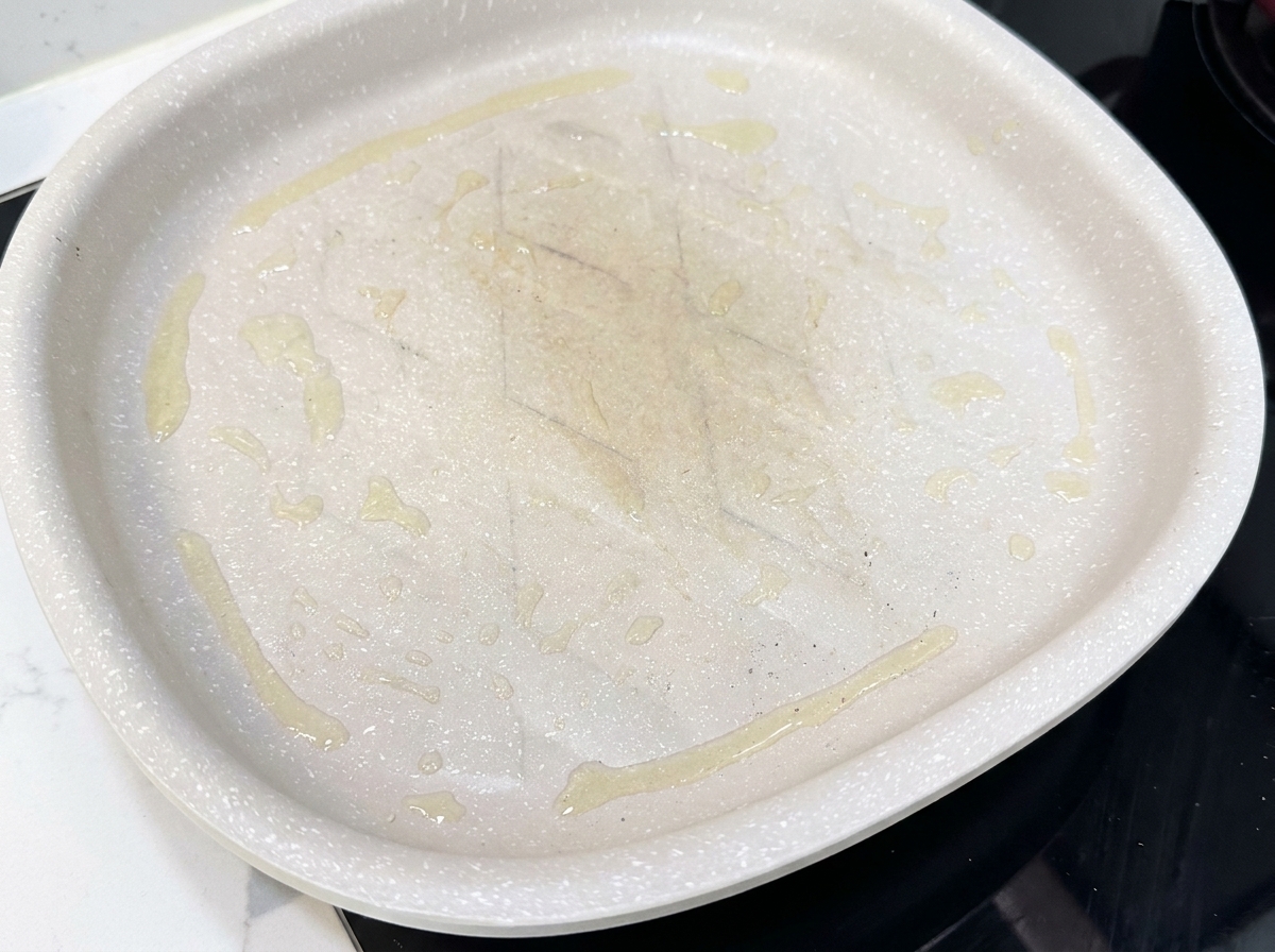 熱したフライパンでベーコンを焼いている様子。