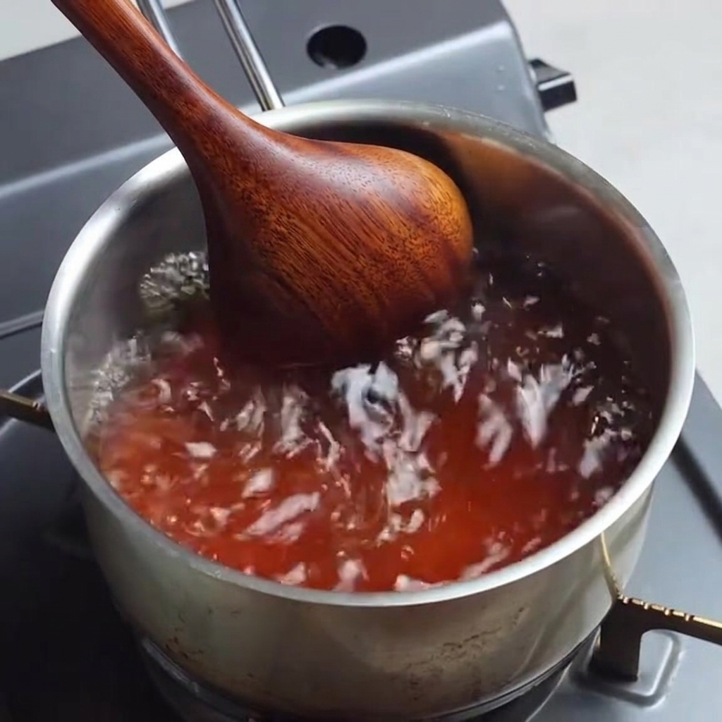 鍋の中で調味料を混ぜながらスープを沸騰させている様子。