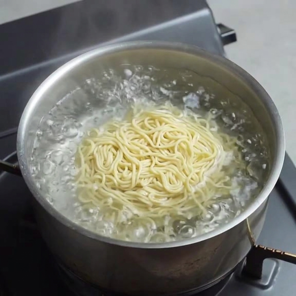 沸騰したお湯で生麺をゆでている様子。