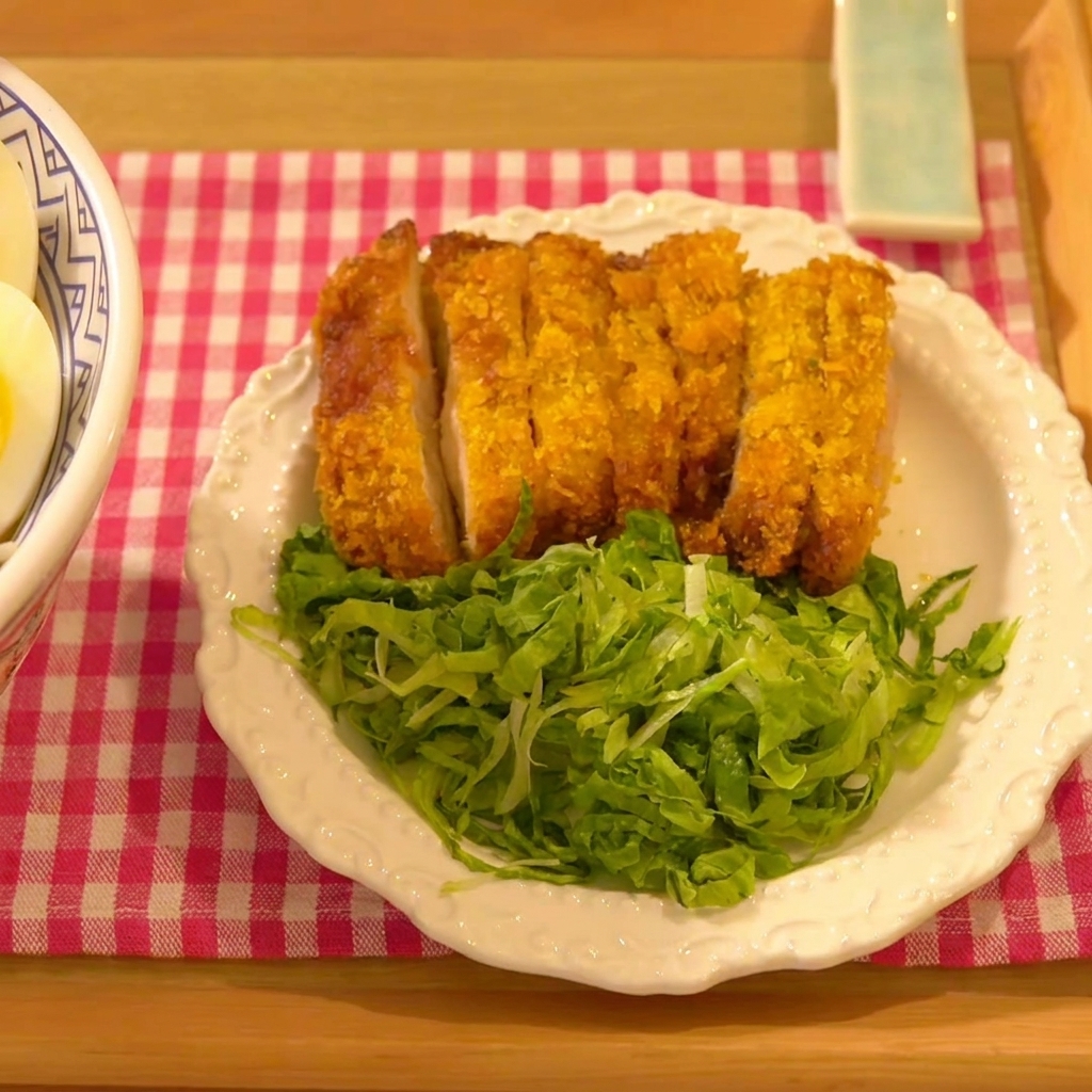 鶏肉をパン粉の入ったボウルに入れ、パン粉をしっかり押さえている様子。
