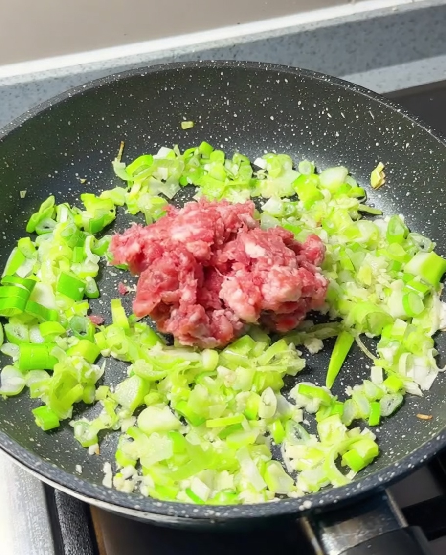 フライパンにひき肉を入れる様子
