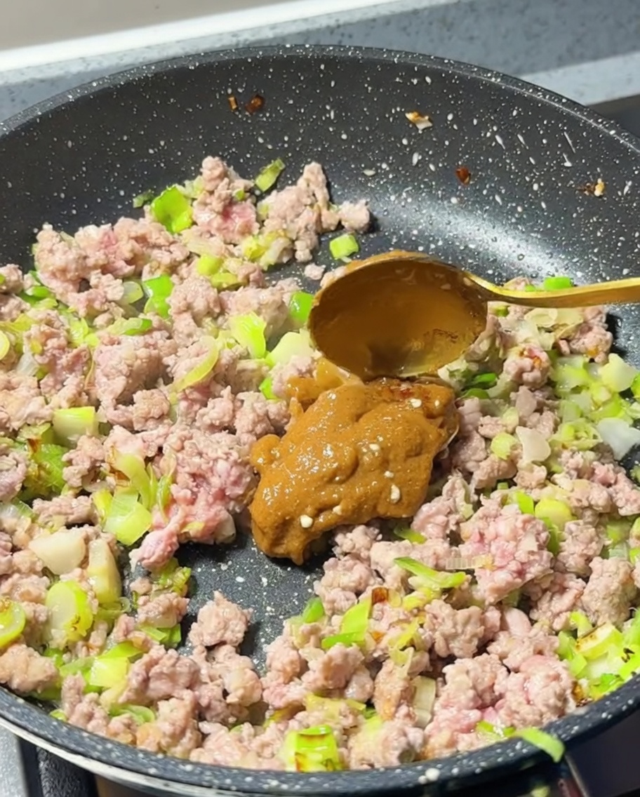 味噌をフライパンに加える様子