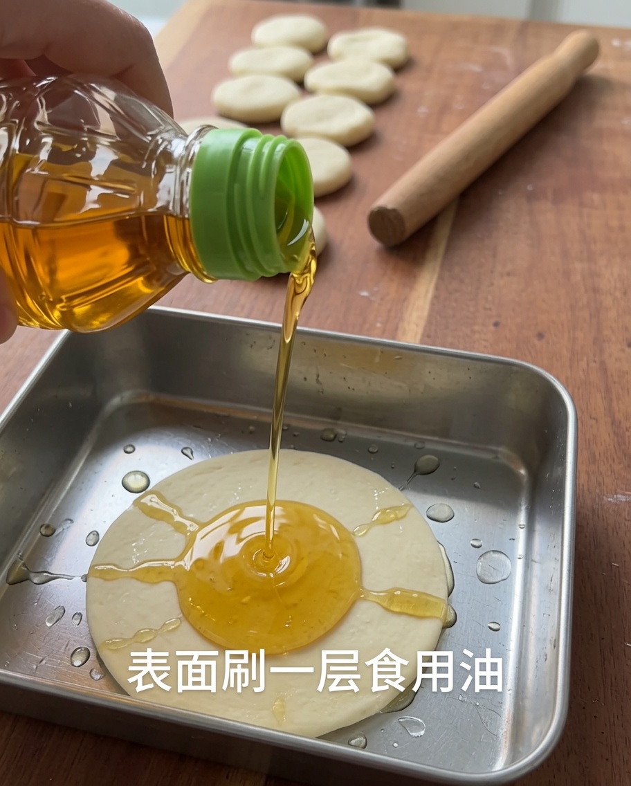 金属製の容器に入った生地に調理用油がかけられている様子。