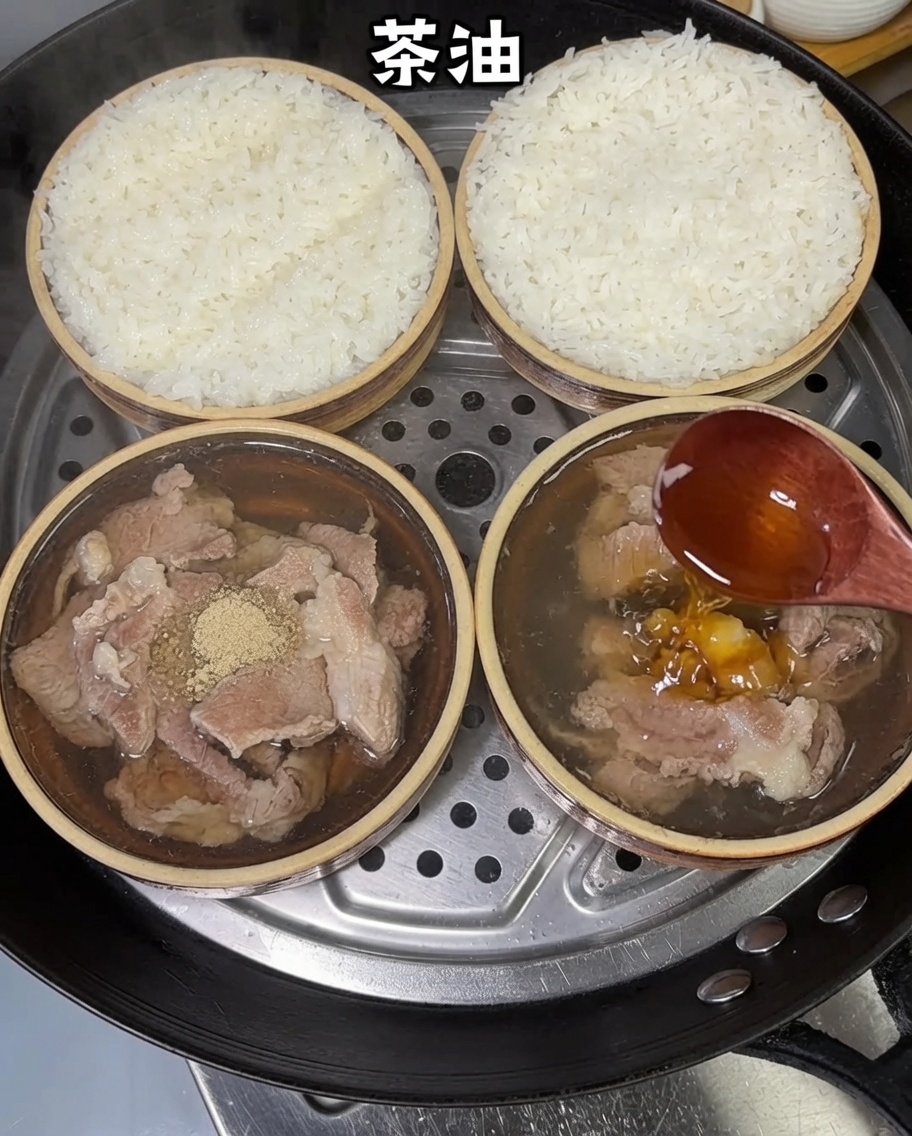 木のさじから茶油が蒸し豚肉ごはんに垂らされている様子。