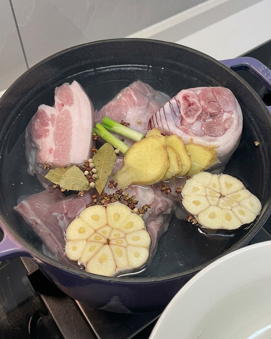 鍋に玉ねぎ、ニンニク、生姜、長ネギ、スパイスを加えた様子