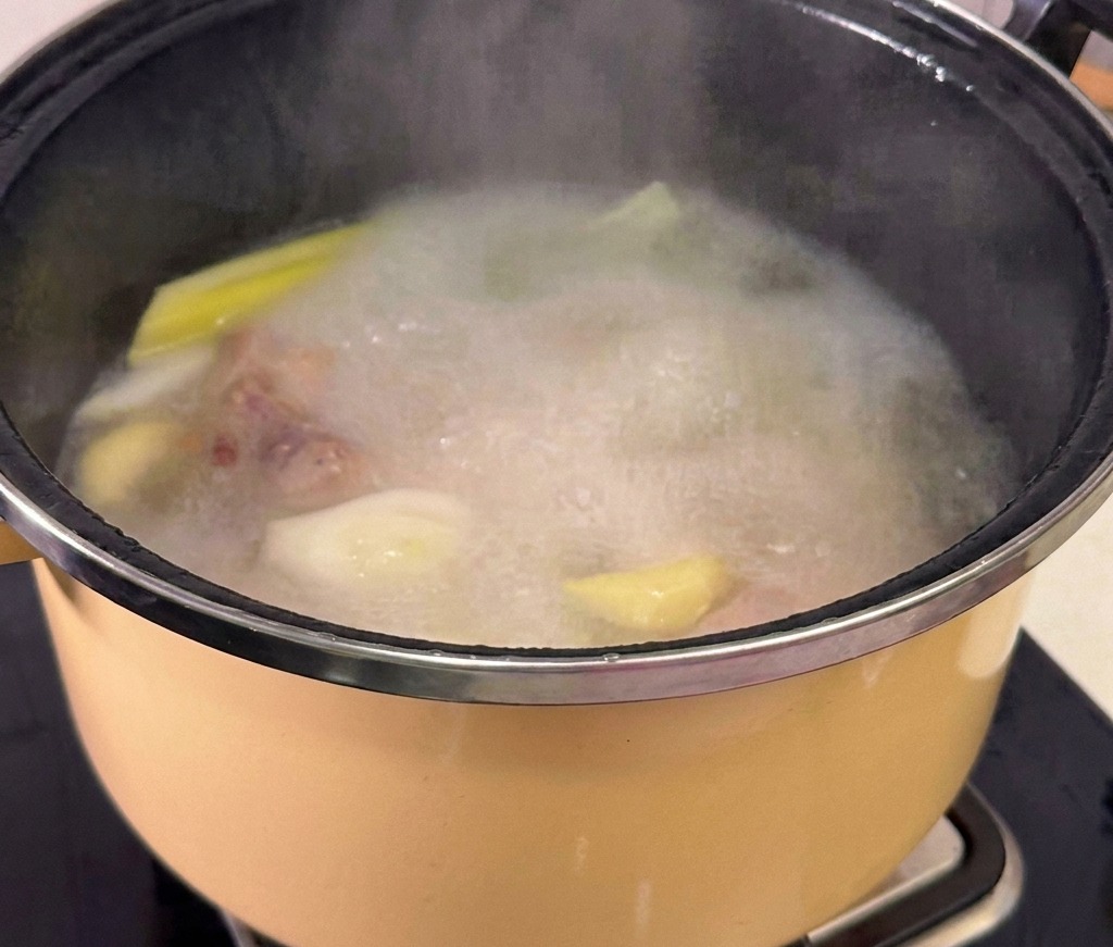 まな板の上で薄切りにされた豚バラ肉。