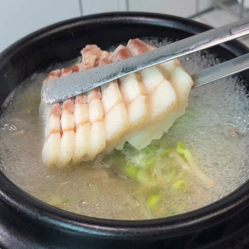 土鍋の中に豚バラ肉とニラを盛り付けている様子。
