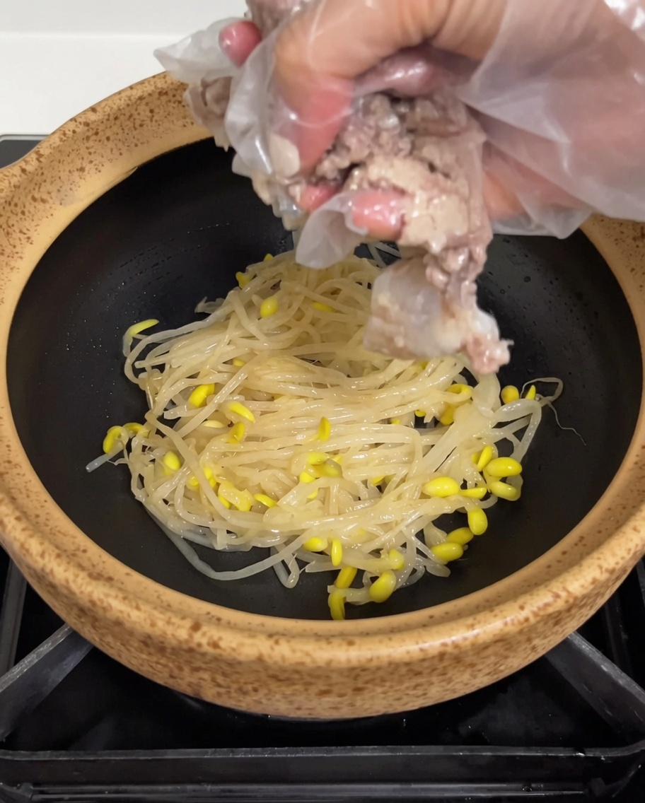 炊き上がった柔らかい豚スペアリブを土鍋に盛り付けている様子。