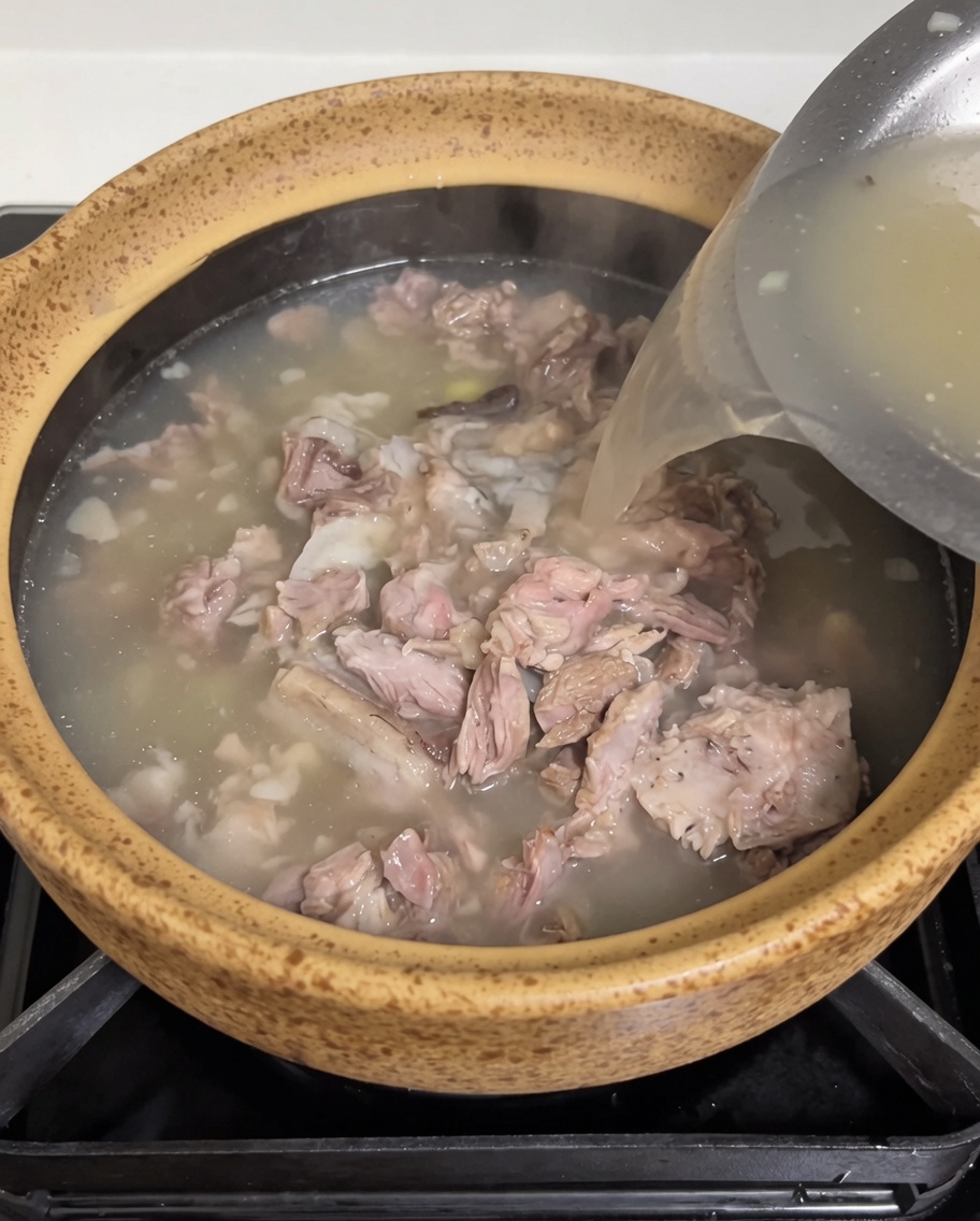 炊飯器から土鍋へ、濁りのある濃厚なスープを注いでいる様子。