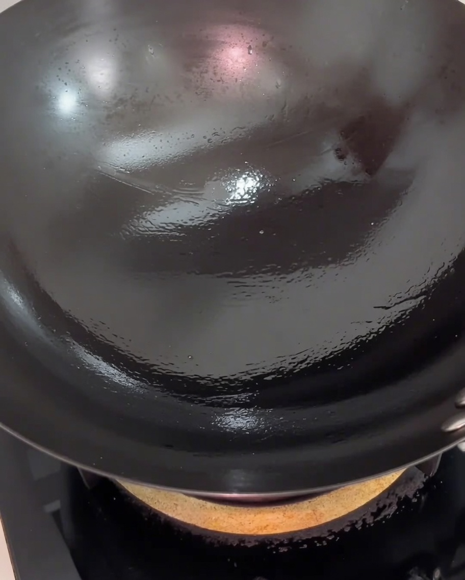 フライパンの中で豚バラ肉がこんがりと色づいている様子。