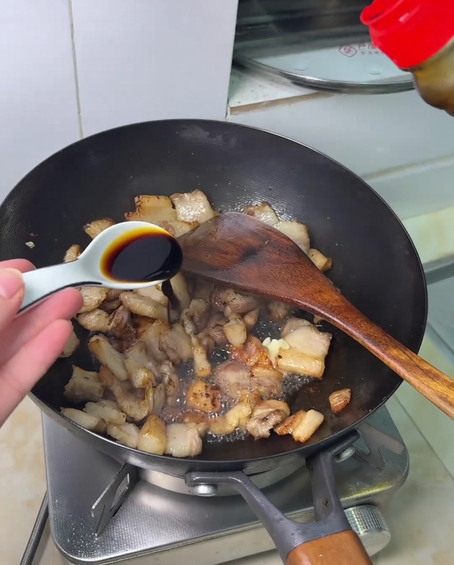 豚肉に醤油を回しかけている様子