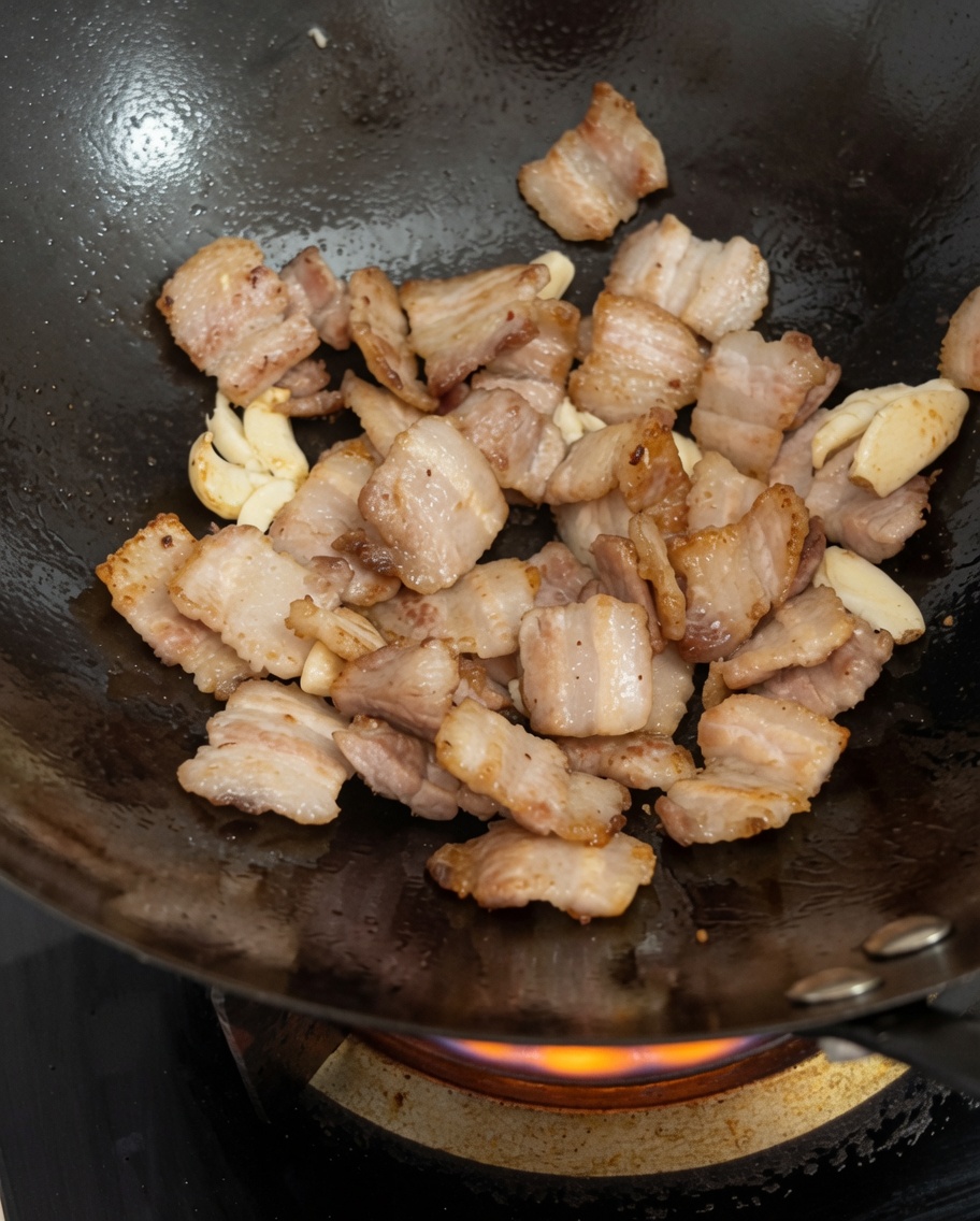 発酵黒豆を鍋に投入し、肉と混ぜ合わせている様子。