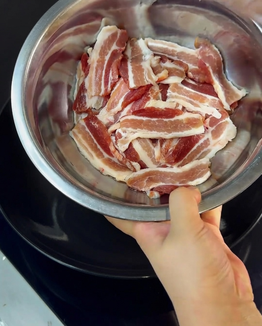 ボウルの中で豚バラ肉と片栗粉を和えている様子