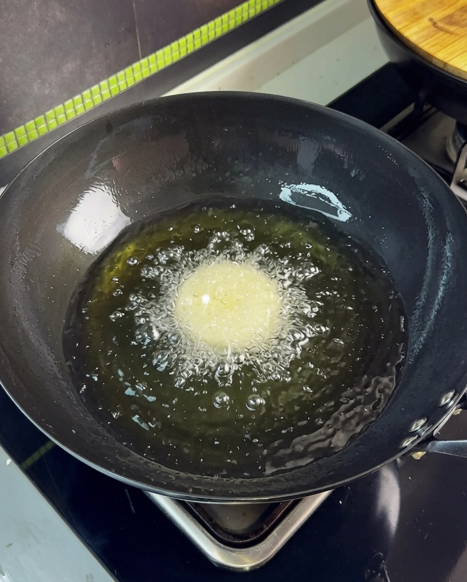 熱した油の中に豚バラ肉を入れた瞬間、泡立っている様子