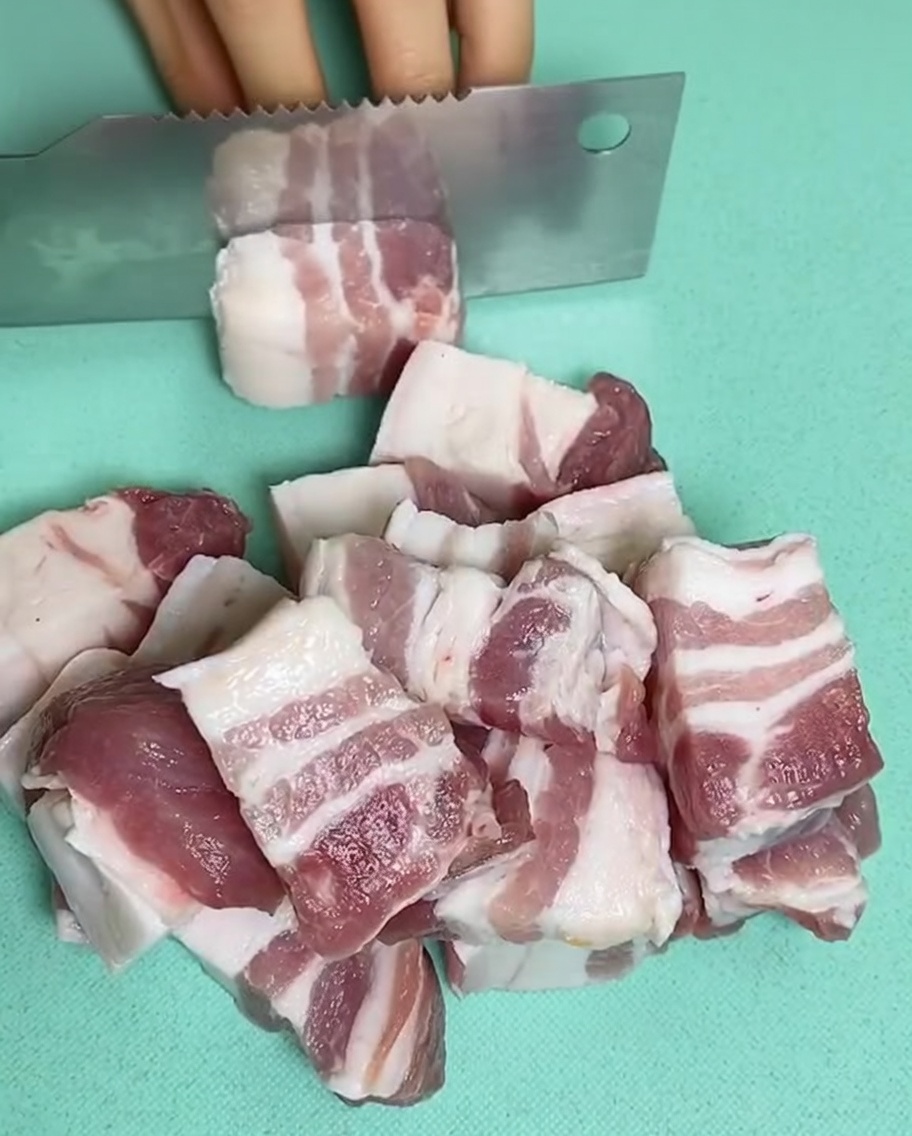 鍋に水、豚バラ肉、生姜、料理酒が入っている様子。