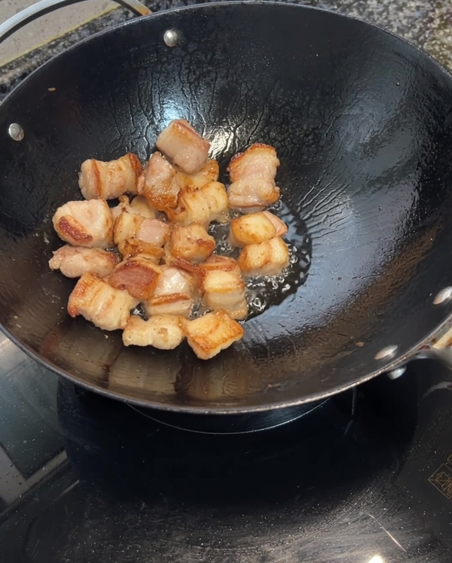 焼き上がった豚肉ににんにくを加えている様子。