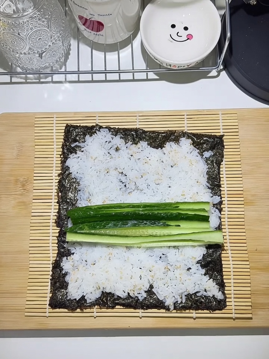 巻きすの上に広げた海苔と、ご飯、具材を並べた様子。