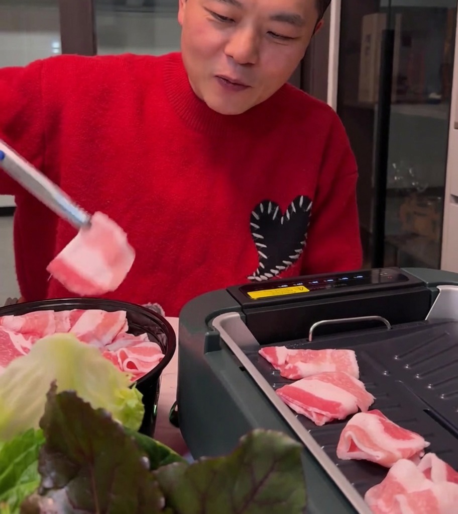 電気グリルで薄切りの豚バラ肉が黄金色に焼けている様子。