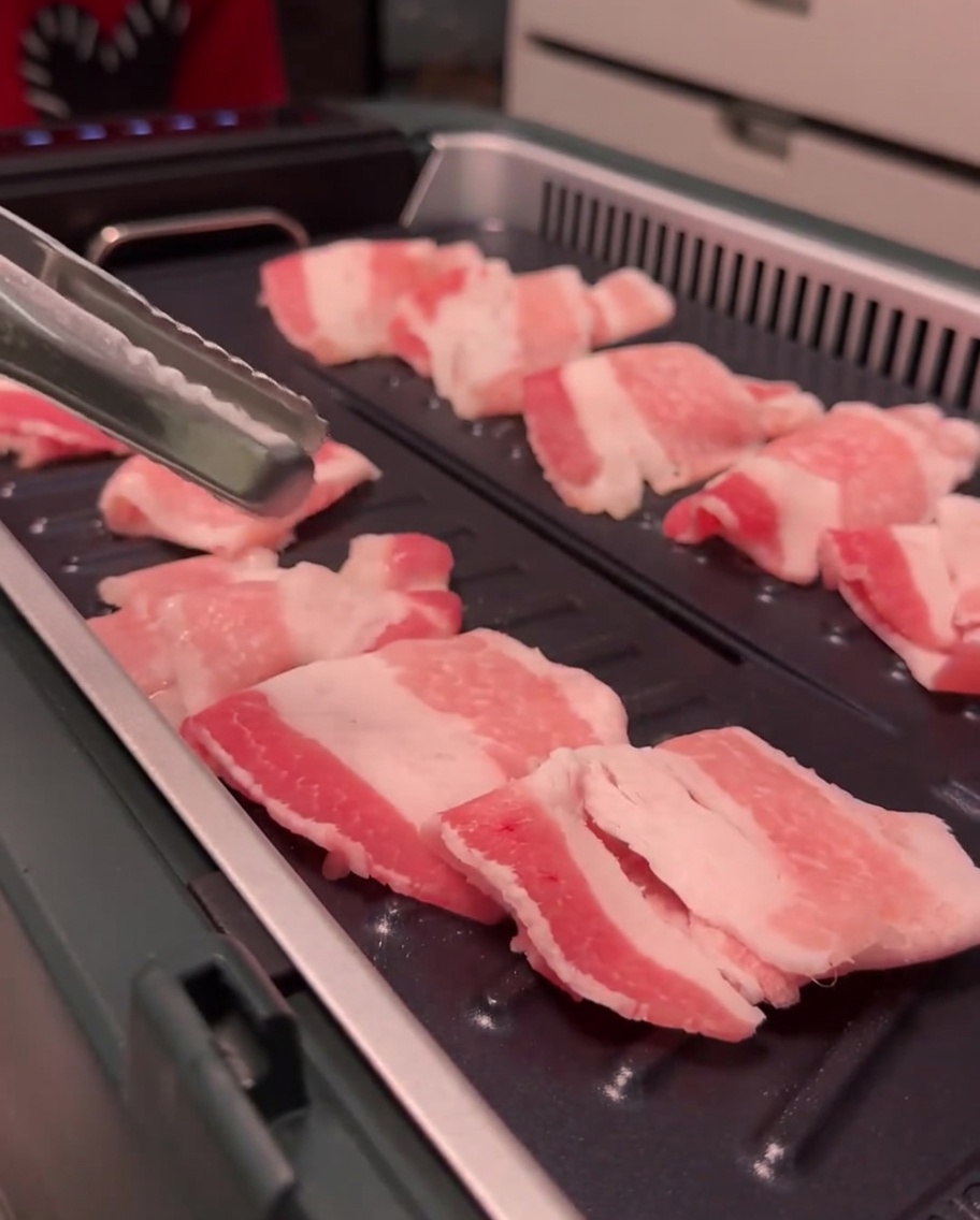 グリル上で豚バラ肉から脂が出てカリカリに焼けている様子。