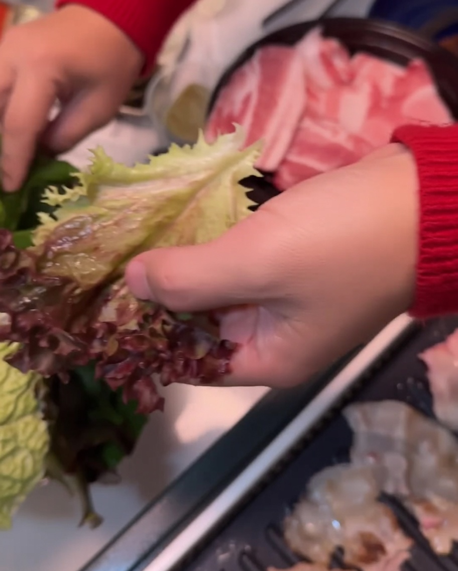 サンチュの上にエゴマの葉を重ねている手元。