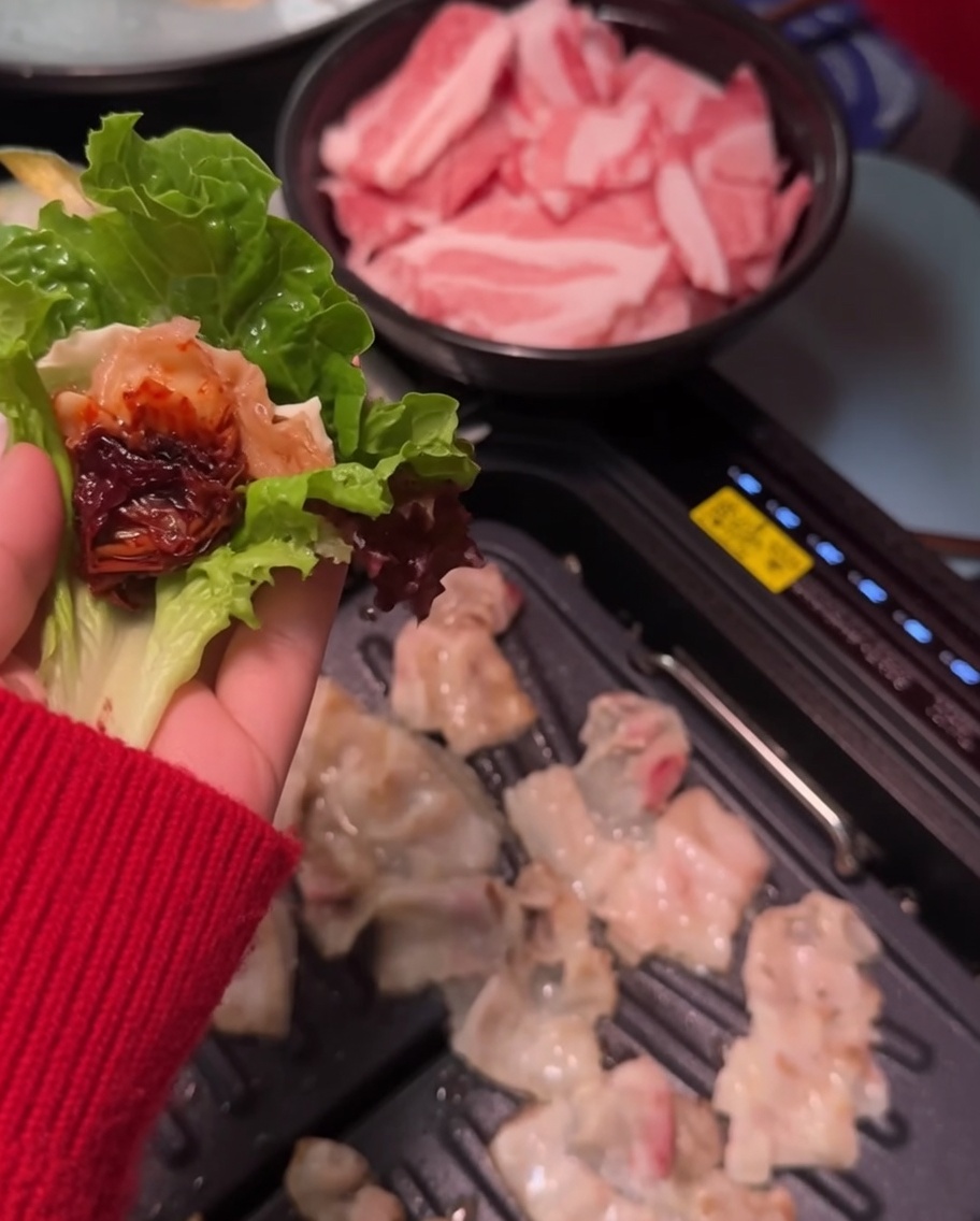 葉の上の肉にサムジャンを付けている様子。