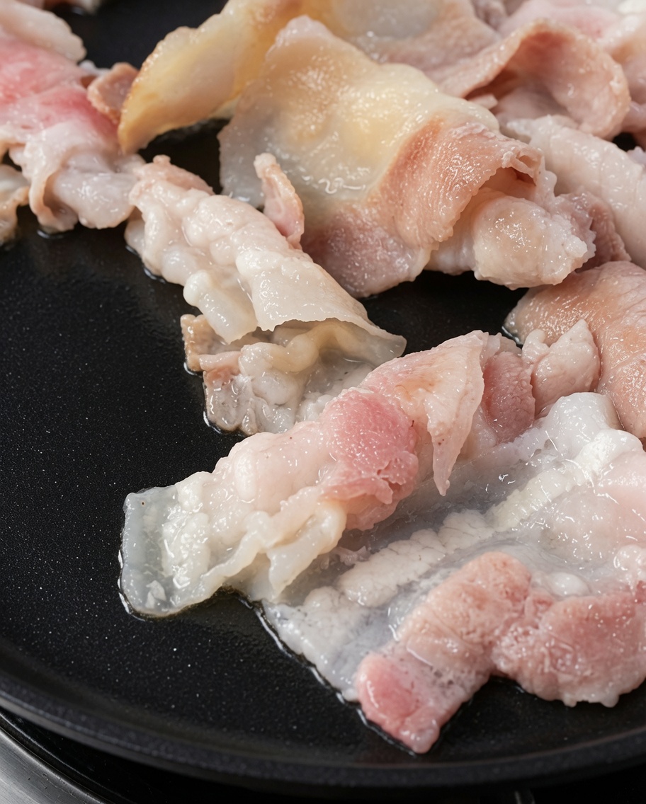 鉄板の上で黄金色に焼けた豚バラ肉。