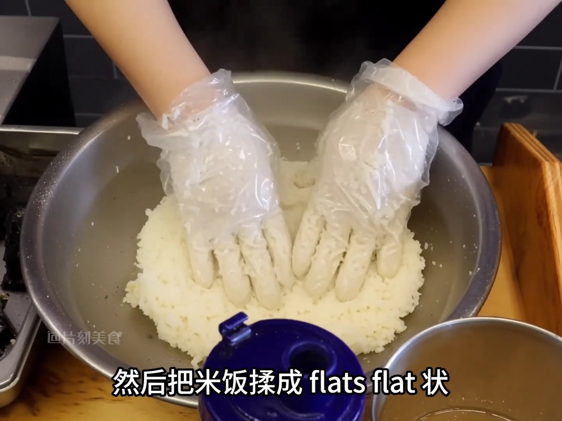 手袋をした手で、味付けしたご飯を平らな丸い形に整えている様子。