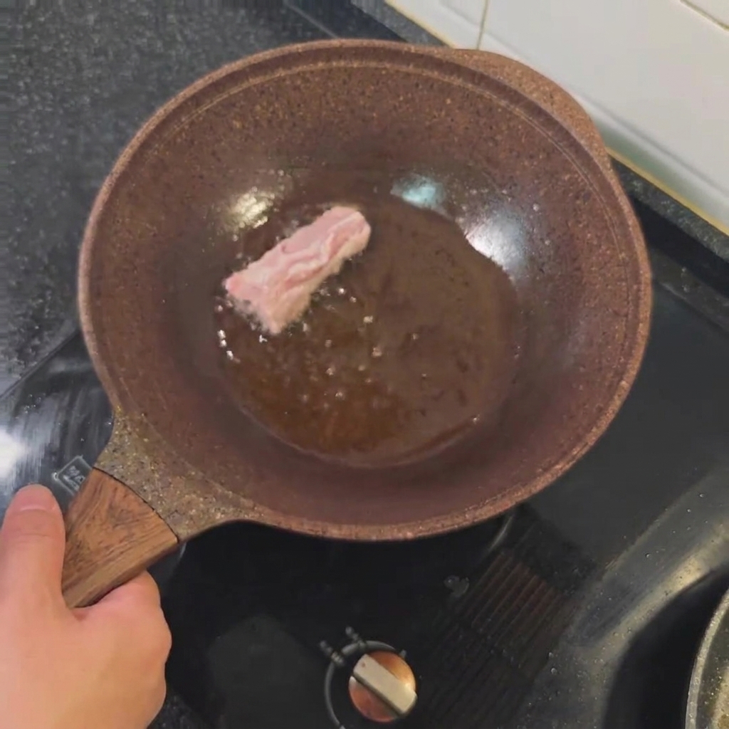 フライパンでこんがりと焼かれている豚スペアリブ。